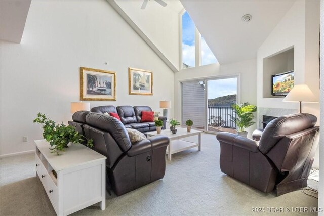 carpeted living room featuring ceiling fan and high vaulted ceiling