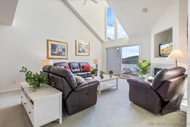 living room featuring carpet floors, baseboards, and high vaulted ceiling