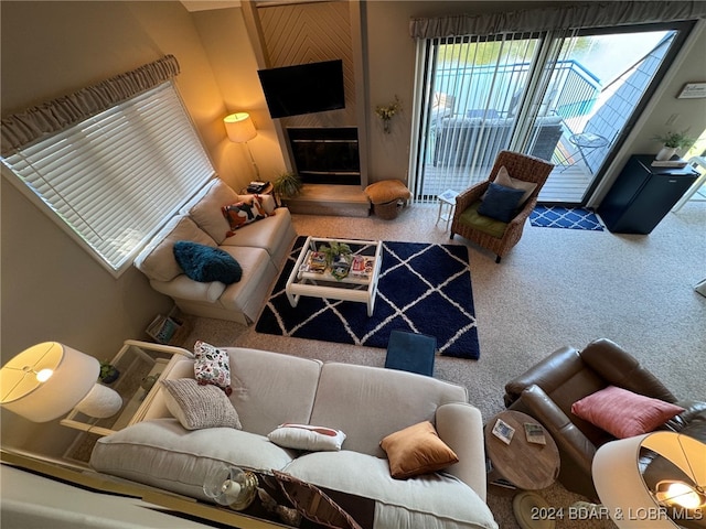 carpeted living room featuring a large fireplace