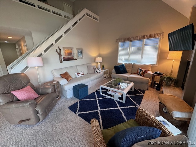 carpeted living room with a high ceiling