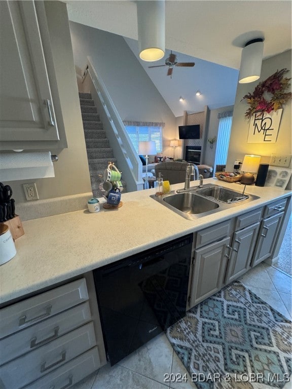 kitchen featuring sink, vaulted ceiling, gray cabinets, light tile patterned floors, and dishwasher