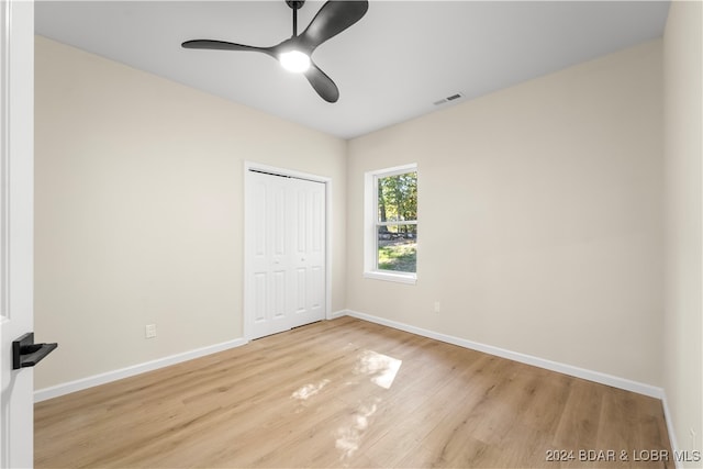 unfurnished bedroom with a closet, light wood-type flooring, and ceiling fan