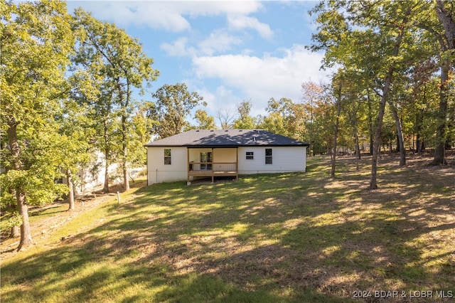 rear view of property with a yard and a deck