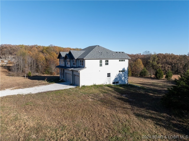 view of side of property with a yard and a garage