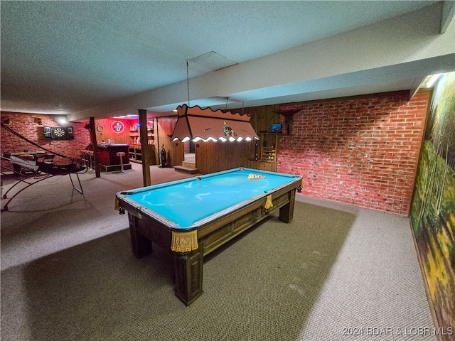 playroom with a textured ceiling, brick wall, carpet, and billiards