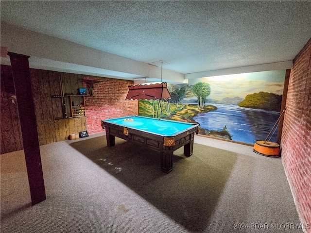 playroom featuring brick wall, a textured ceiling, wooden walls, carpet, and pool table