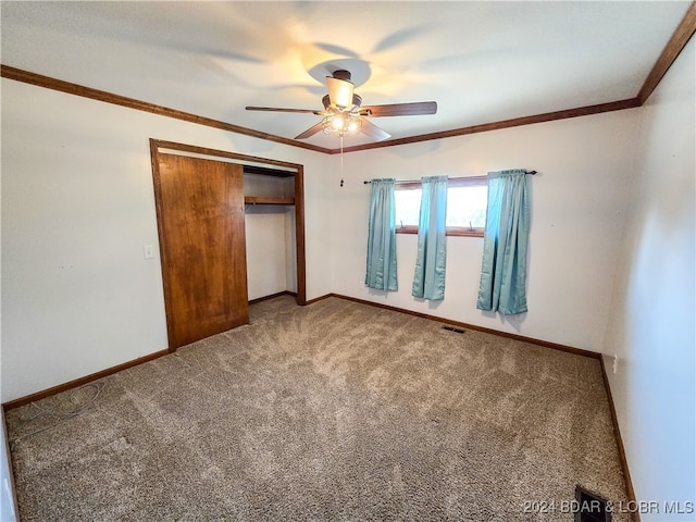 unfurnished bedroom with crown molding, ceiling fan, carpet floors, and a closet