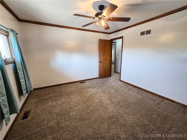 carpeted spare room featuring ornamental molding and ceiling fan