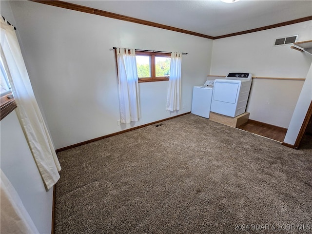 laundry area with dark carpet, crown molding, and washing machine and dryer