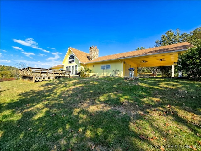 back of house featuring a wooden deck and a lawn