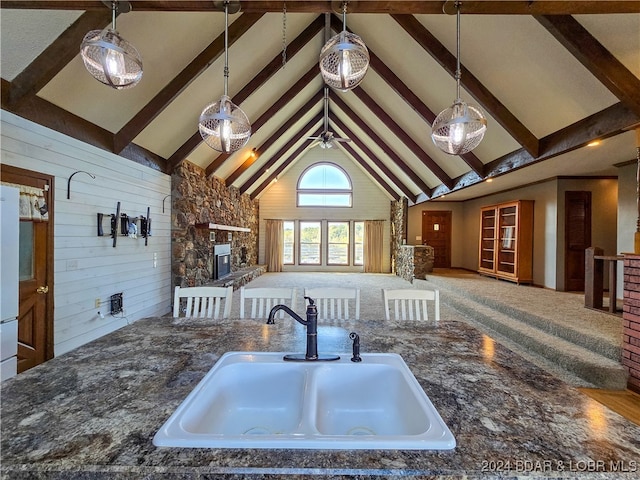 kitchen with ceiling fan, high vaulted ceiling, beam ceiling, and sink