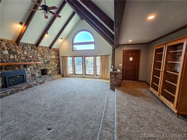 unfurnished living room with high vaulted ceiling, a stone fireplace, beamed ceiling, and carpet flooring