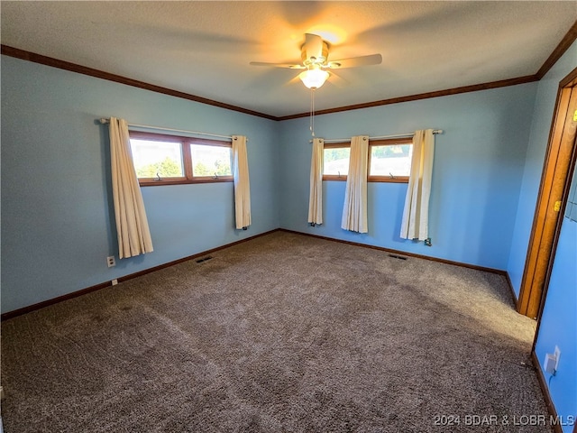 empty room featuring ornamental molding, carpet, a textured ceiling, and ceiling fan