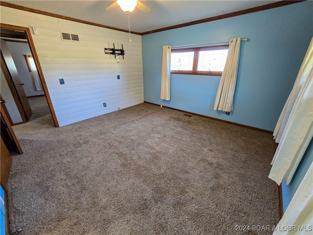 unfurnished bedroom with ornamental molding, ceiling fan, and carpet