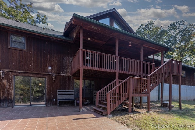 back of property featuring a deck and a patio area