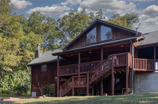 back of house featuring a wooden deck and a lawn