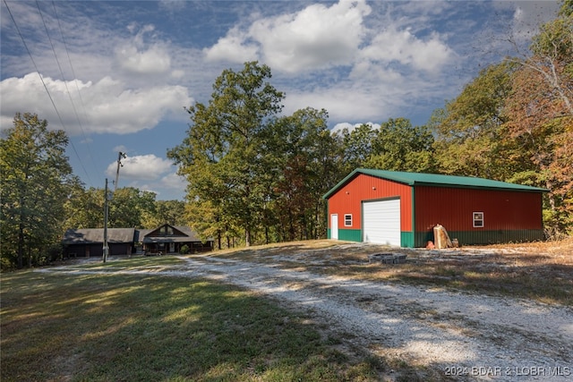 view of outdoor structure featuring a garage and a lawn