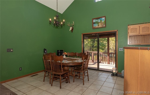 dining area featuring light tile patterned flooring, high vaulted ceiling, and an inviting chandelier