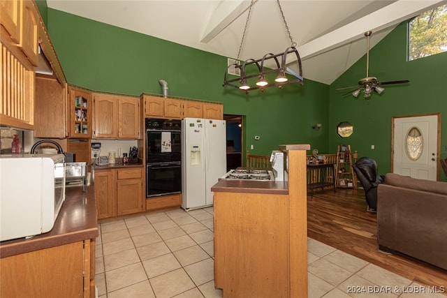 kitchen with ceiling fan, light hardwood / wood-style flooring, black double oven, white fridge with ice dispenser, and high vaulted ceiling