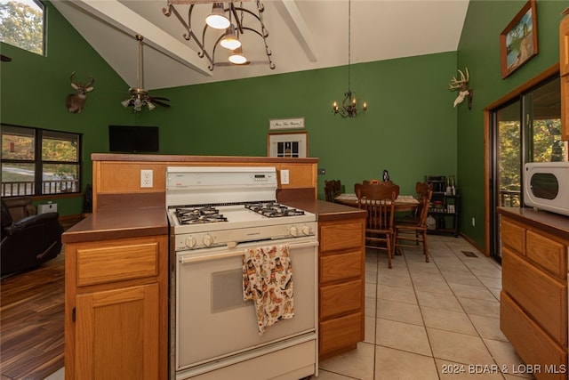 kitchen featuring pendant lighting, light tile patterned floors, white appliances, high vaulted ceiling, and ceiling fan with notable chandelier