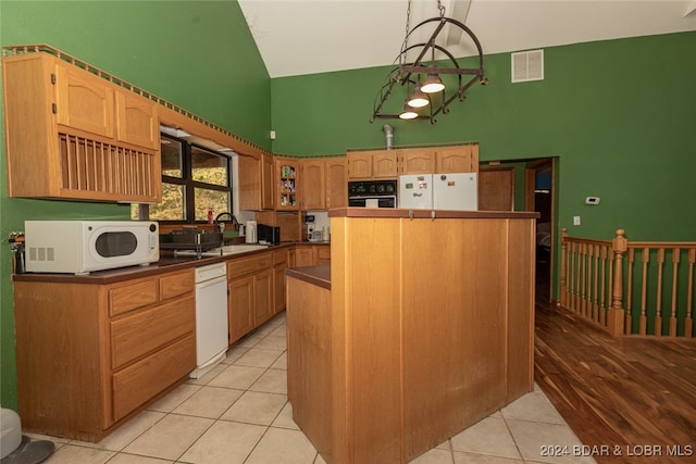 kitchen featuring sink, white appliances, decorative light fixtures, light hardwood / wood-style flooring, and a center island