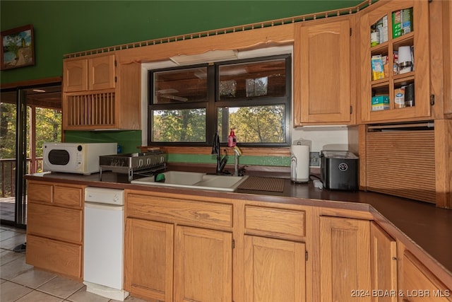 kitchen featuring sink, light tile patterned floors, and a healthy amount of sunlight