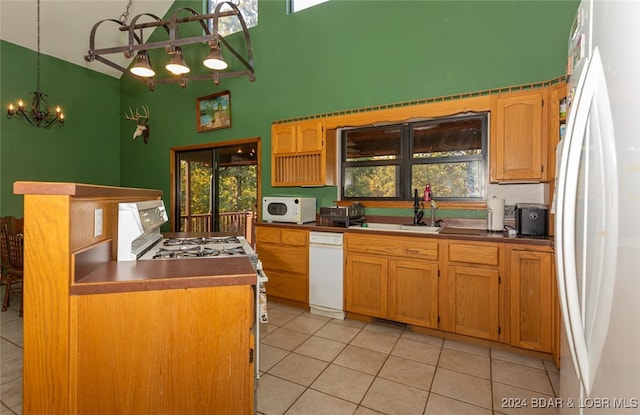 kitchen with a notable chandelier, white appliances, and a healthy amount of sunlight