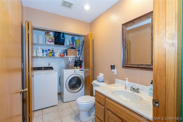 laundry room featuring washing machine and dryer, sink, and light tile patterned flooring