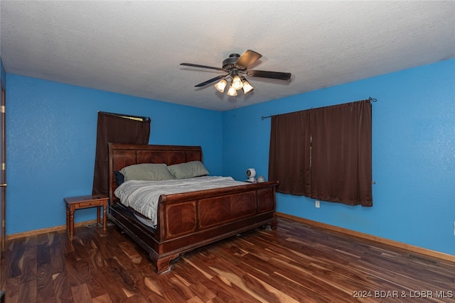 bedroom featuring ceiling fan, dark hardwood / wood-style floors, and a textured ceiling