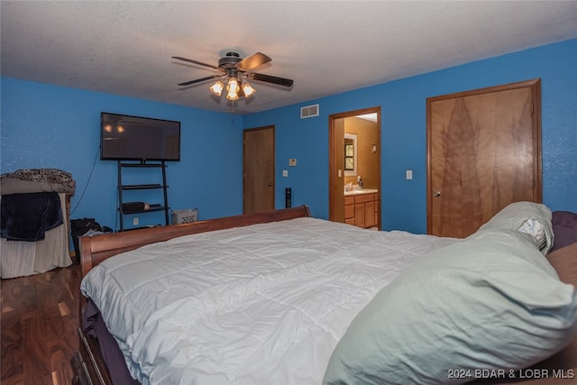 bedroom with ceiling fan, sink, a textured ceiling, dark hardwood / wood-style floors, and ensuite bathroom