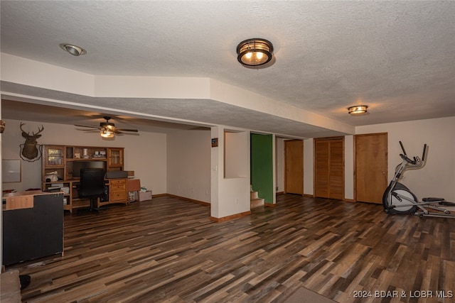 living room featuring ceiling fan, dark hardwood / wood-style floors, and a textured ceiling