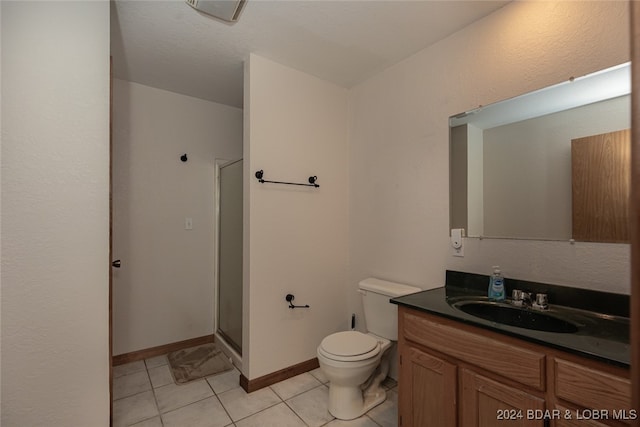 bathroom featuring vanity, toilet, an enclosed shower, and tile patterned floors