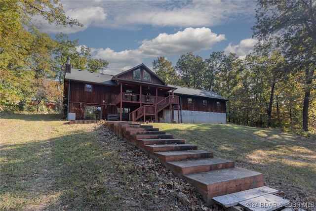 rear view of house featuring a yard and a deck