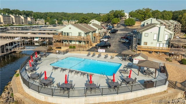 view of pool with a water view and a patio