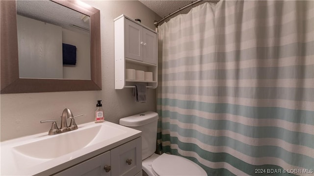 bathroom with vanity, a textured ceiling, and toilet