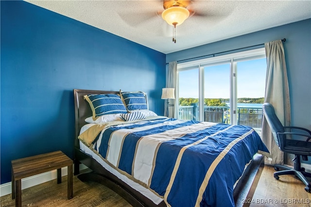 bedroom featuring wood-type flooring, access to exterior, a textured ceiling, and ceiling fan