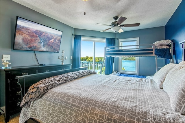 bedroom featuring access to exterior, ceiling fan, wood-type flooring, and a textured ceiling