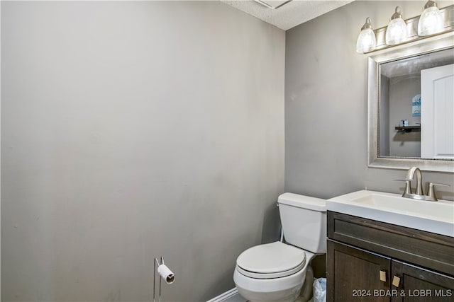 bathroom featuring vanity, toilet, and a textured ceiling