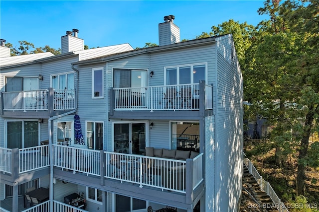 back of property featuring outdoor lounge area and a balcony