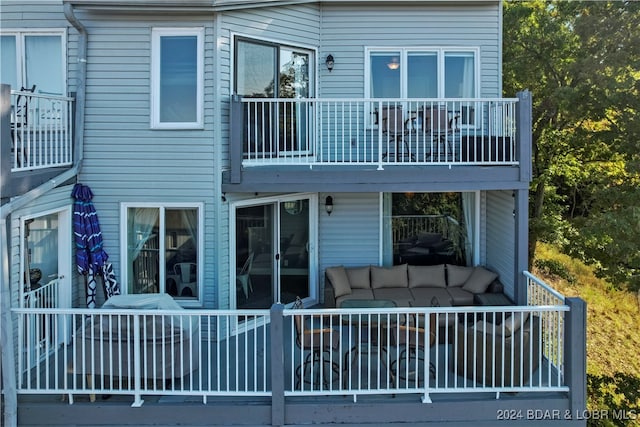 back of property featuring an outdoor living space and a balcony