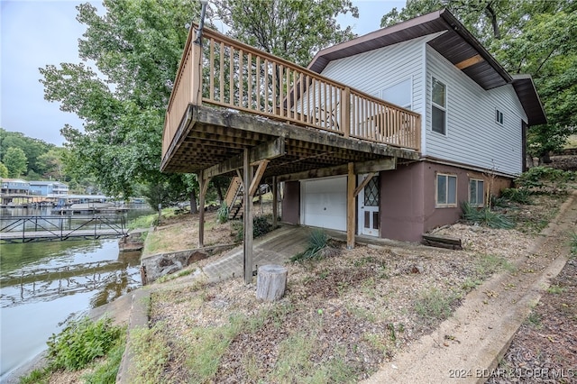 back of property featuring a deck with water view