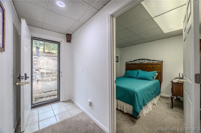 carpeted bedroom featuring access to outside and a drop ceiling