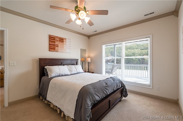 carpeted bedroom with ceiling fan and ornamental molding