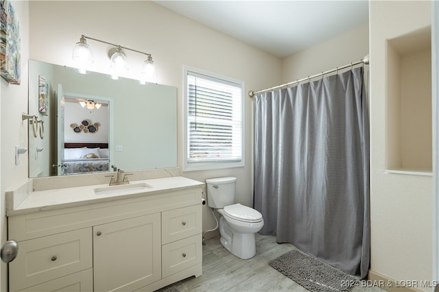 bathroom featuring hardwood / wood-style flooring, vanity, and toilet