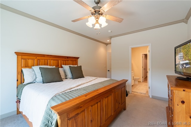 bedroom featuring ornamental molding, ensuite bathroom, ceiling fan, and light colored carpet