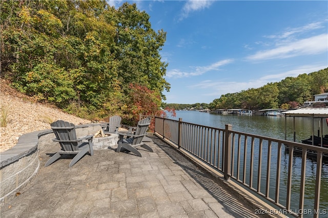 view of patio / terrace featuring a dock, a water view, and an outdoor fire pit