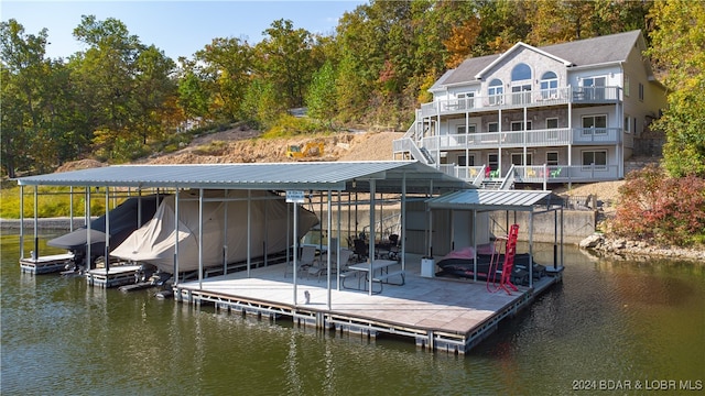 dock area with a water view and a balcony