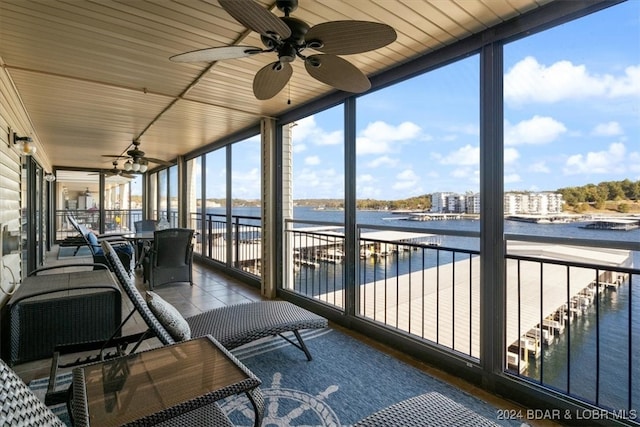 unfurnished sunroom with a water view, ceiling fan, and wooden ceiling