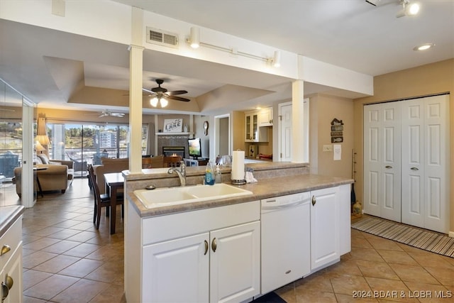 kitchen with white dishwasher, sink, light tile patterned floors, and white cabinetry