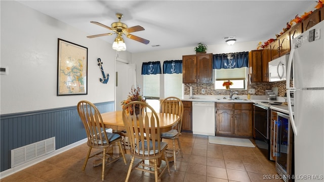 kitchen with dark tile patterned floors, ceiling fan, decorative backsplash, white appliances, and sink